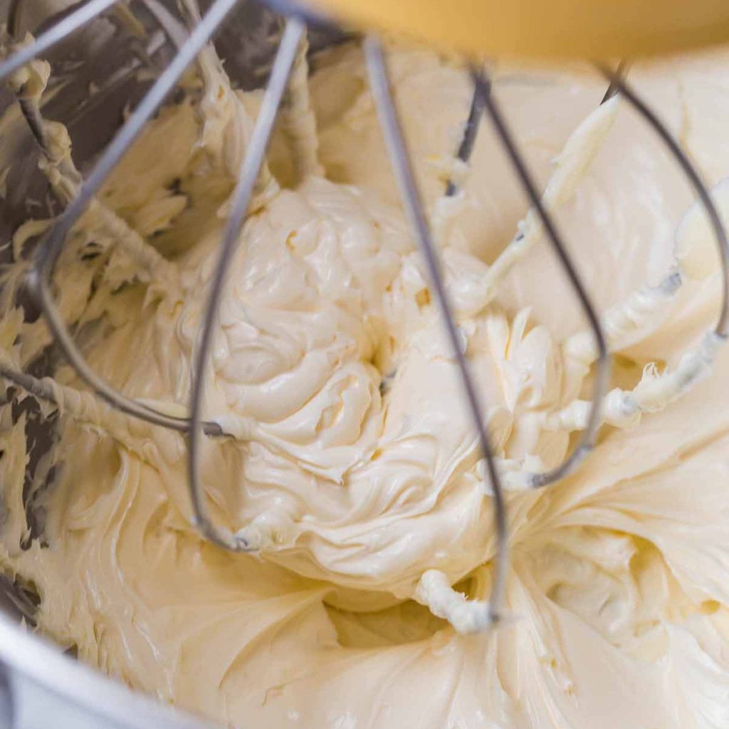 close up of mixer attachment mixing butter for frosting