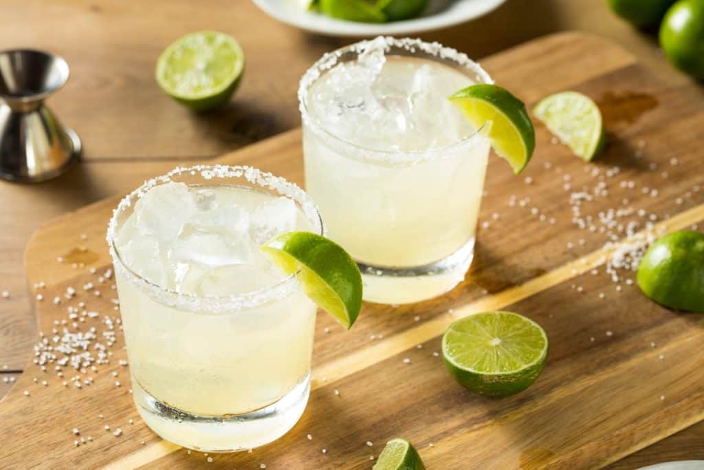two classic margaritas in glasses with a lime wedge garnish