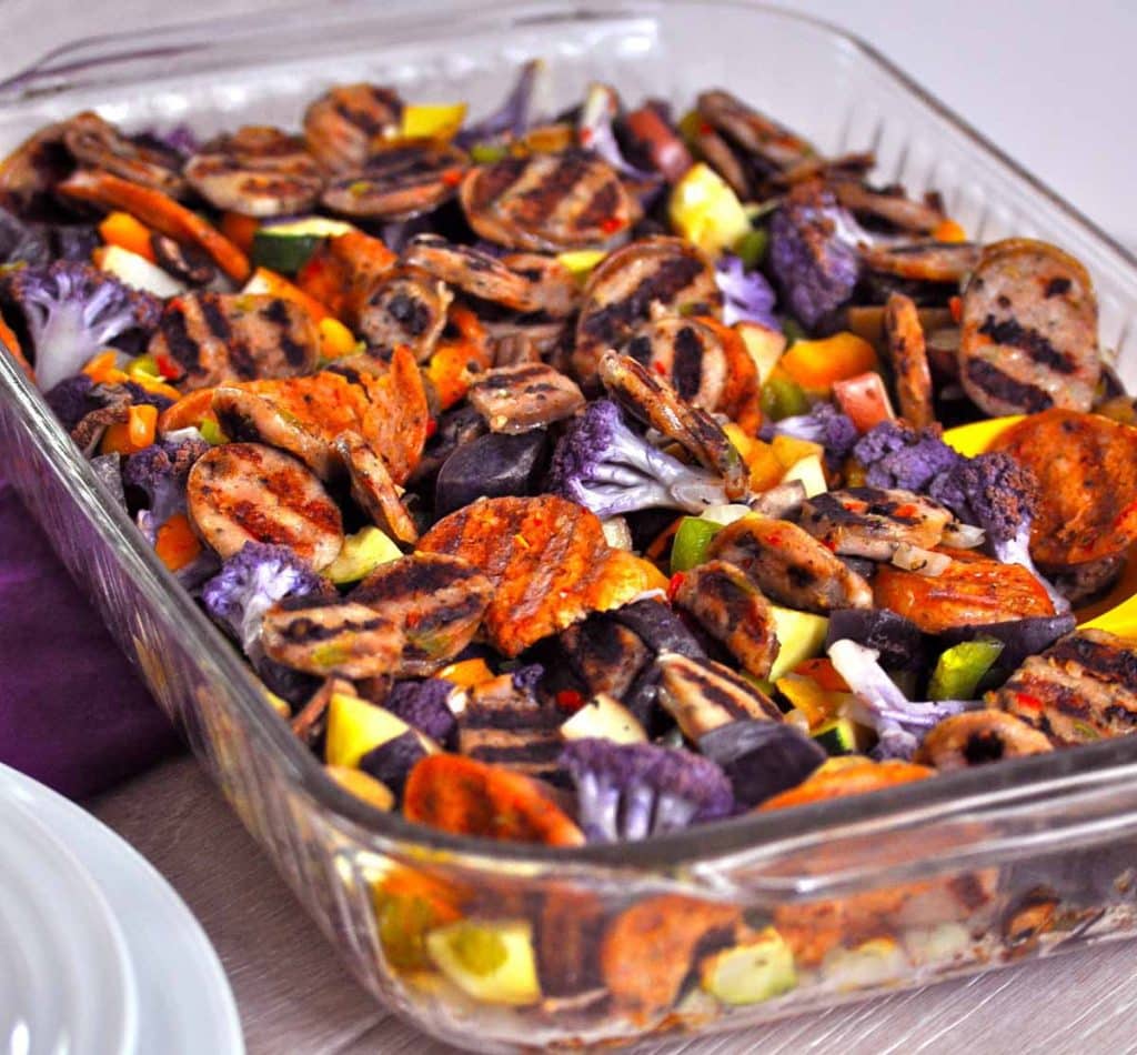 cooked vegetables and sausage in a glass baking dish
