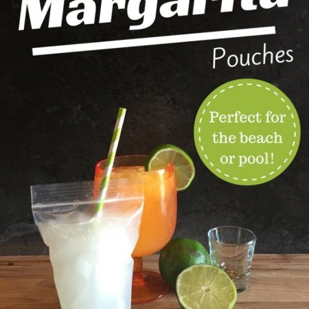 Image of portable margarita in front of traditional margarita glass. There are limes and a shot glass to the right.