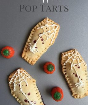 three coffin pop tarts on a gray counter with candy pupmkins