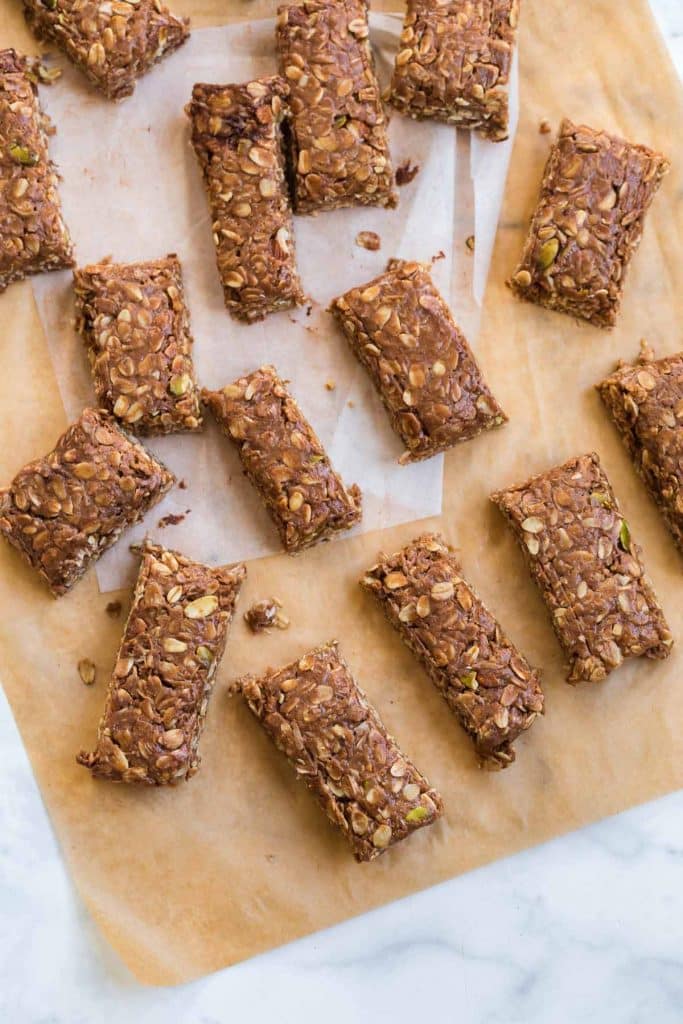 cut homemade granola bars on top of parchment paper