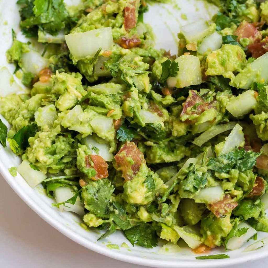 close up of guacamole in a white bowl