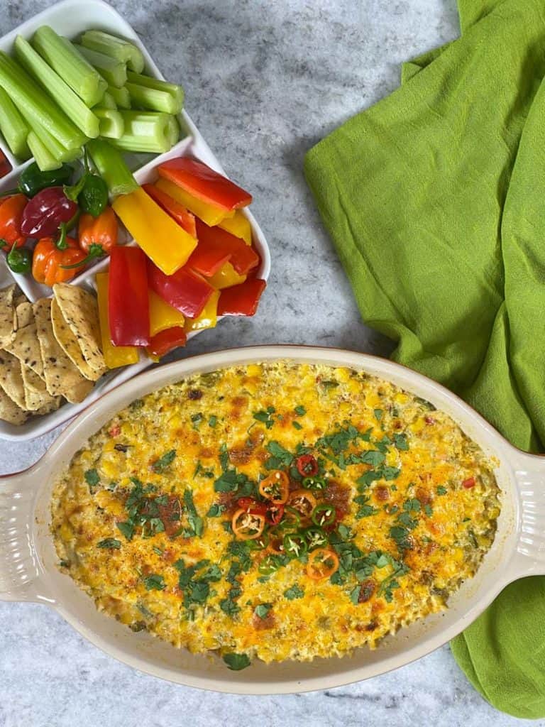corn dip in dish with veggies and chips on the side