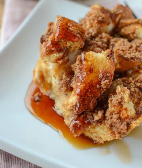 french toast casserole with maple syrup on a white plate