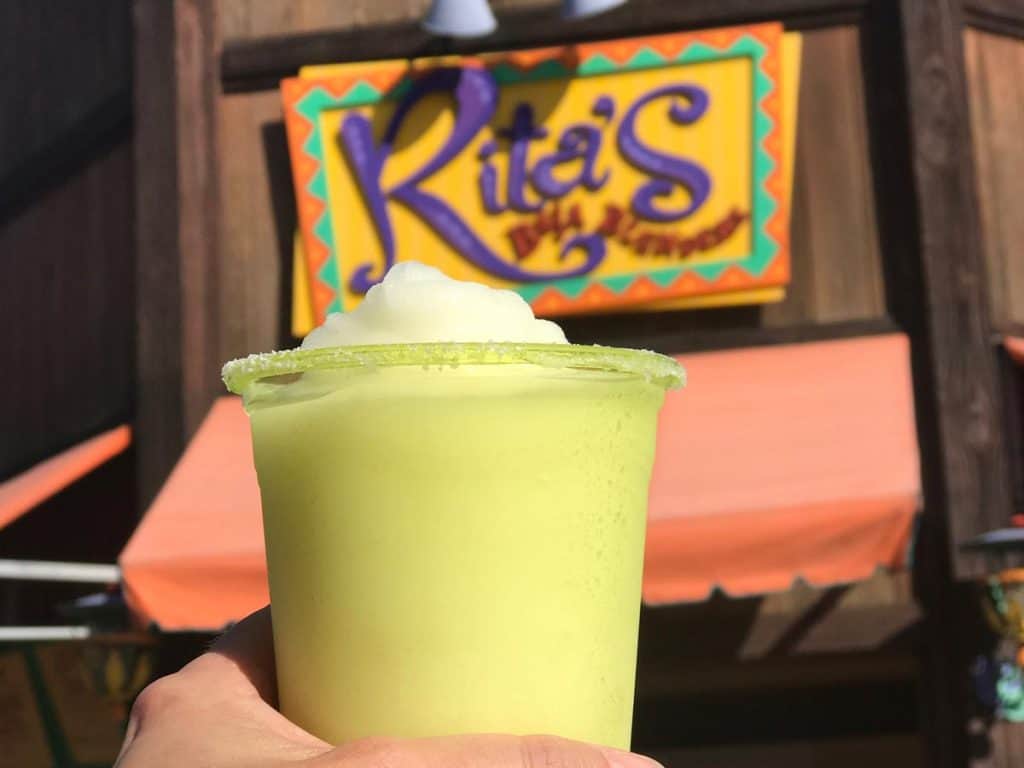 frozen margarita being help up in front of Rita's Margarita Stand in California Adventure