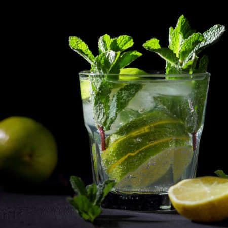 glass with ice, lime slices, mint and water