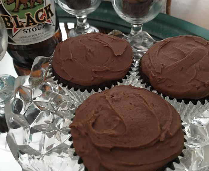 close up of vegan chocolate cupcakes with stout beer in the background