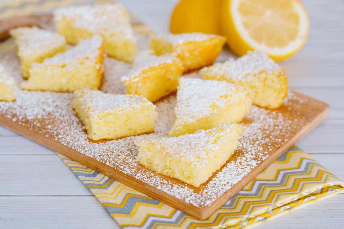 3 Ingredient Lemon Bars from Cake Mix on wood cutting board.