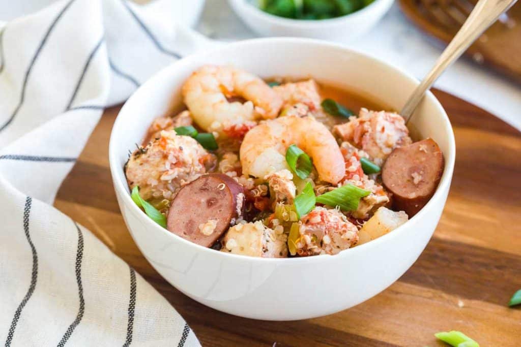 White bowl filled with crockpot jambalaya. This bowl includes both shrimp and sausage.