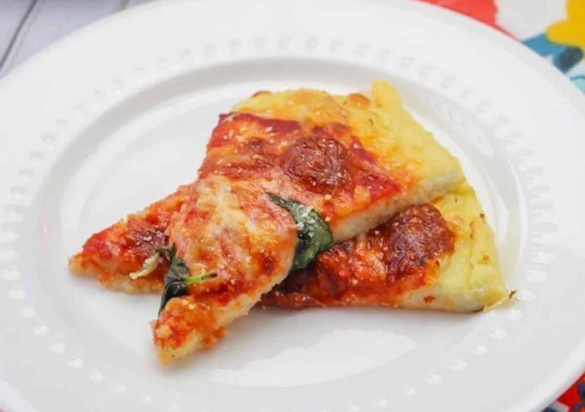Two slices of cooked low carb pizza crust recipe on a white plate.