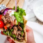 close up of hand holding steak gyro