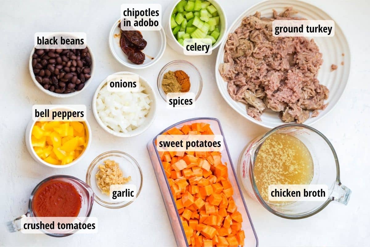 A white counter top with bowls and plates full of ingredients that are labeled to make instant pot sweet potato chili.