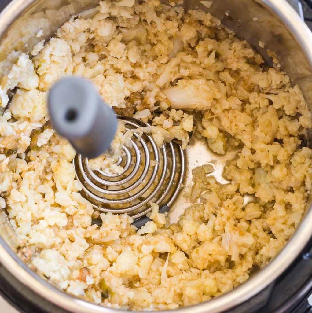cauliflower being mashed inside of an Instant Pot