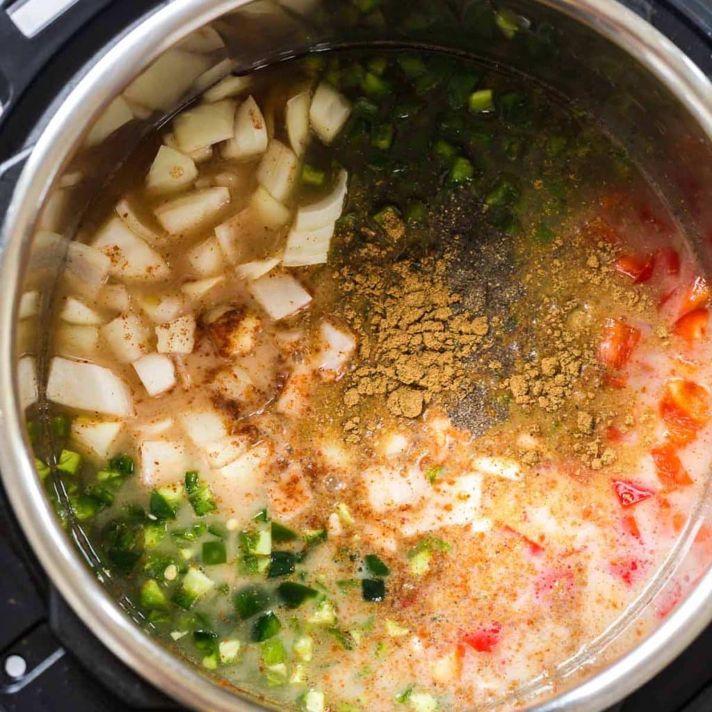An instant pot with broth, dry beans and vegetables to make weight watchers white chicken chili.