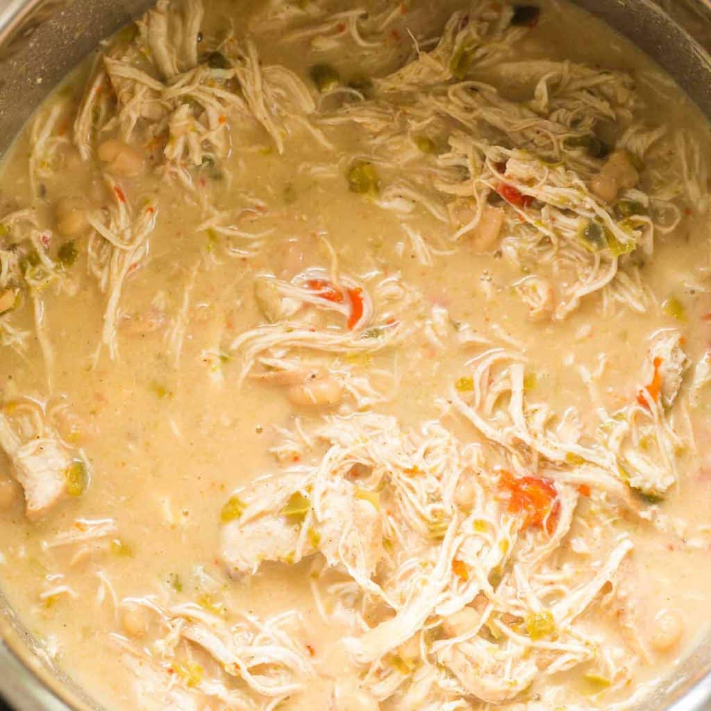 Creamy white chicken chili in an Instant Pot, with tender shredded chicken, white beans, and a rich, thick broth, ready to serve.