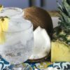 pineapple slice, coconut slice, and two pina coladas on a tray