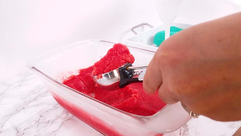 margarita slush being scooped out of pan with ice cream scoop