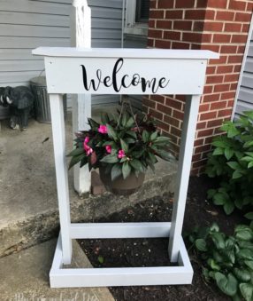 This DIY welcome sign is made with a Cricut and s a great weekend project. It's not too complicated and a DIY plant hanger makes a lovely addition to the front yard, porch, or give it as a gift!