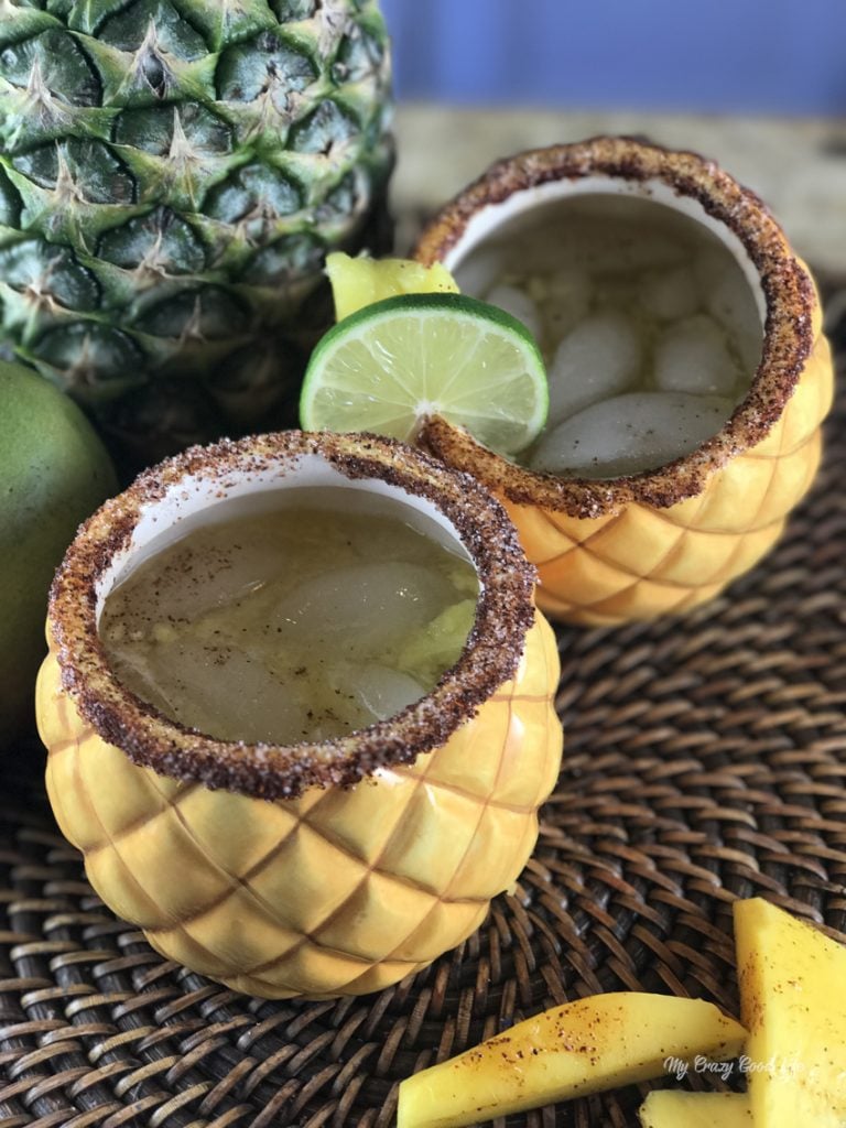 pineapple ceramic glasses with margarita in them, rimmed with tajin and siugar