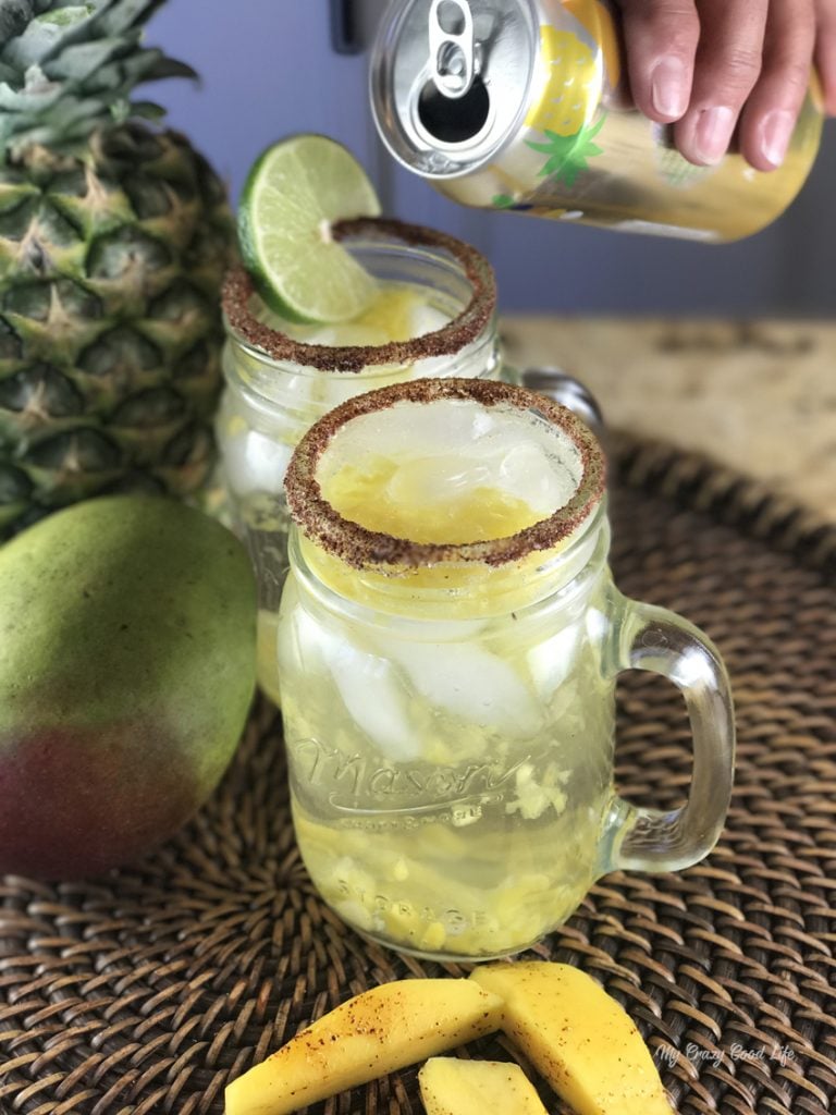 pouring sparkling water into a mason jar glass