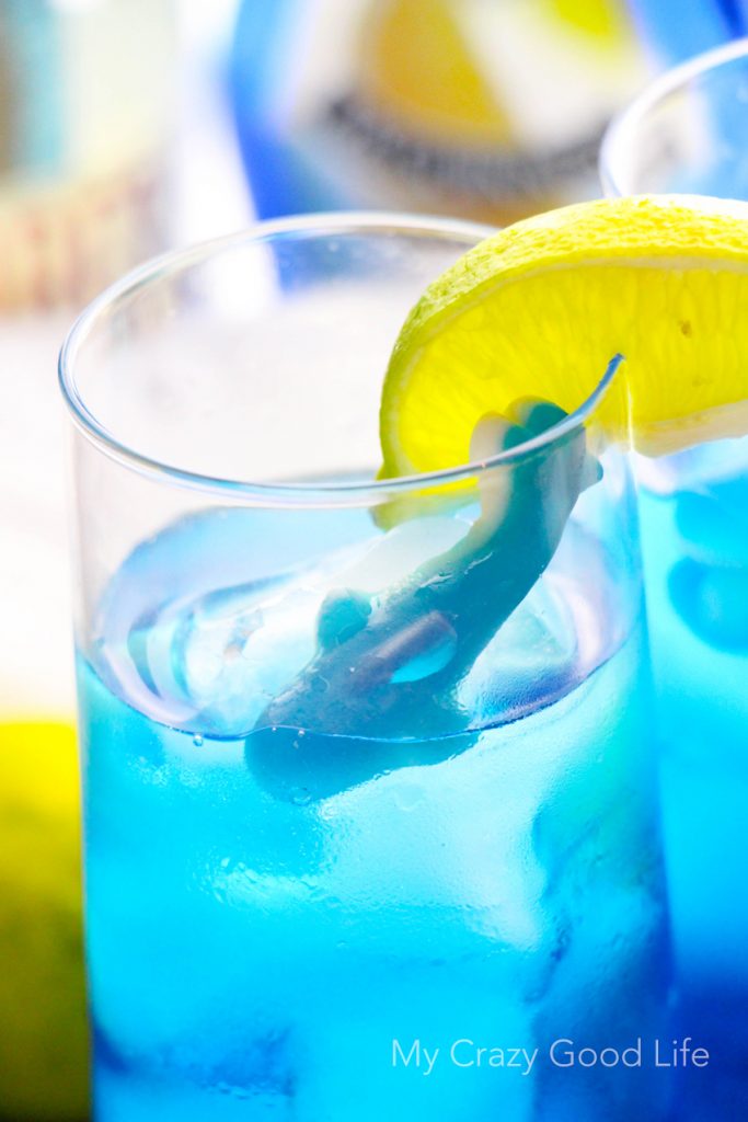 There's nothing better than curling up on the couch and enjoying Shark Week with a drink! This fun Shark Bite Margarita is the perfect Shark Week companion! Be careful... this one is strong, and it bites back! Shark Week Cocktails | Blue Margarita | Shark Week Margarita