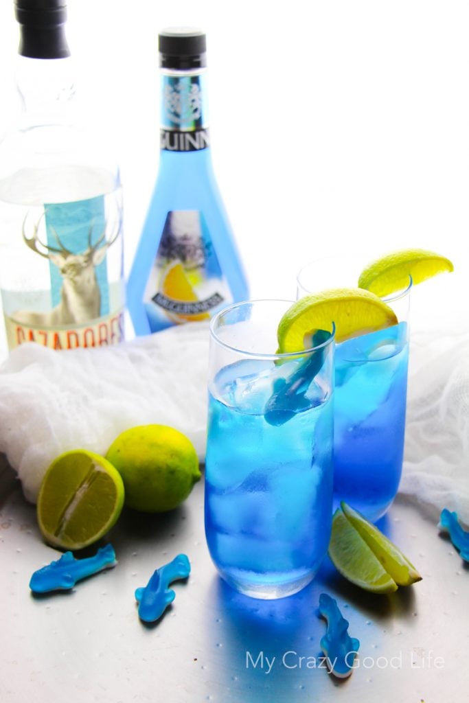 There's nothing better than curling up on the couch and enjoying Shark Week with a drink! This fun Shark Bite Margarita is the perfect Shark Week companion! Be careful... this one is strong, and it bites back! Shark Week Cocktails | Blue Margarita | Shark Week Margarita