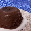 small chocolate cake on a plate with blue towel in background