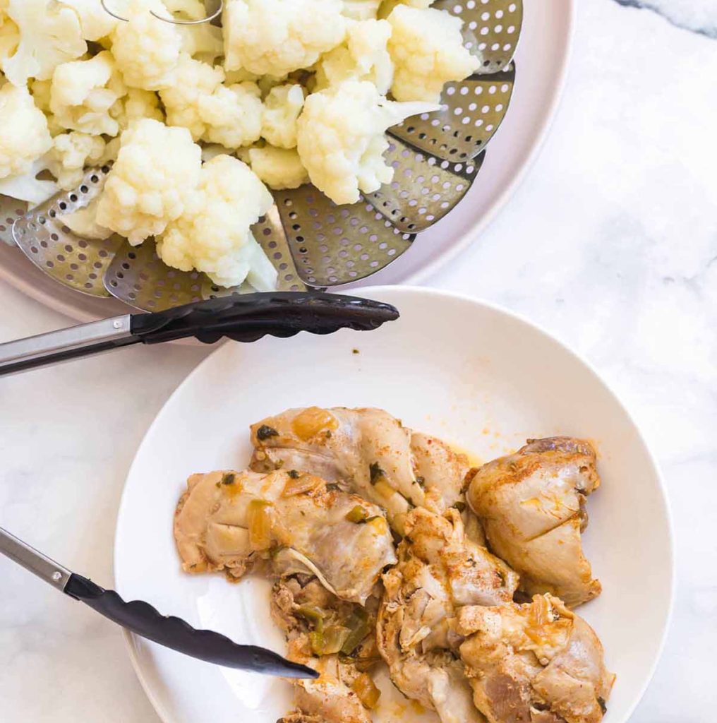 cooked cauliflower and cooked chicken thighs on a white counter