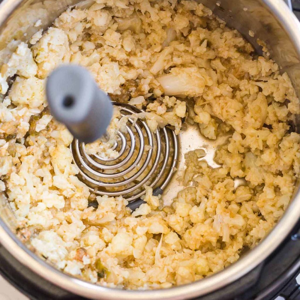 cauliflower being mashed inside of an Instant Pot
