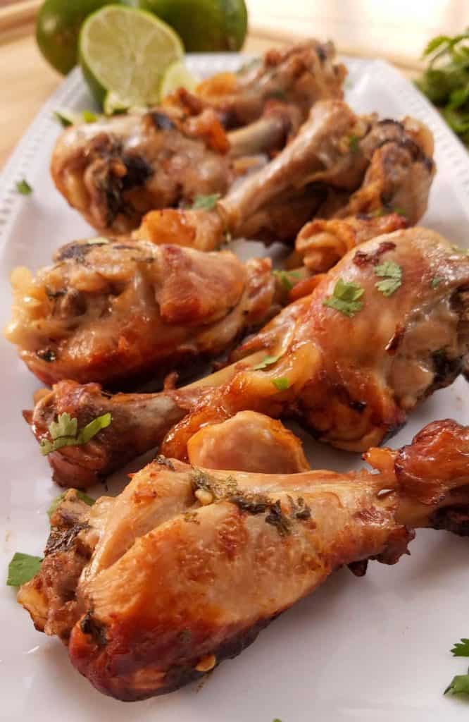 cooked chicken drumsticks on a white rectangular plate