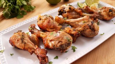cooked chicken drumsticks on a white rectangular plate