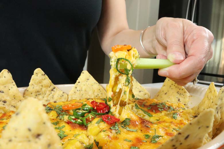 dipping celery into corn dip