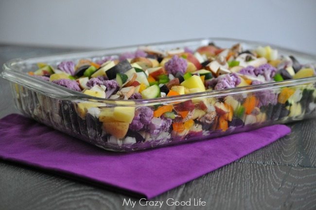 Casserole on a purple napkin on top of a wooden table.