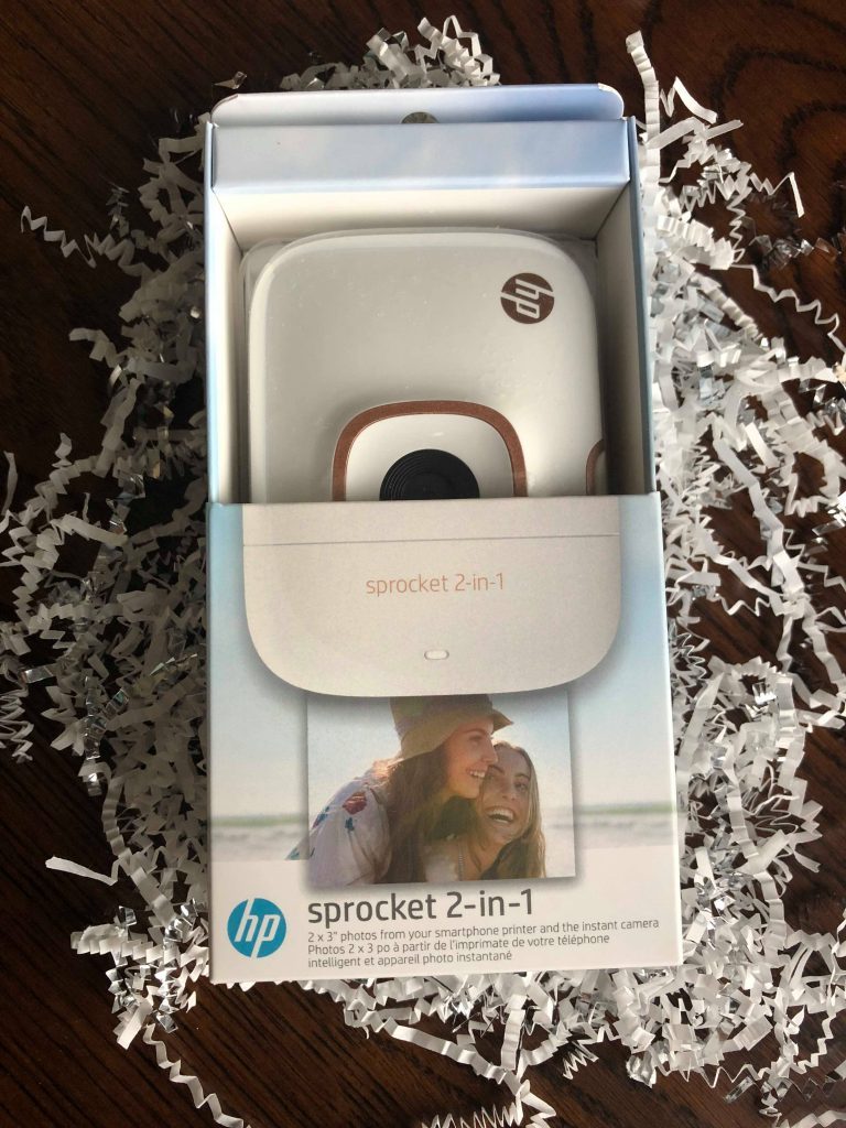 Photo of the Sprocket 2-in-1 printer on white crinkle paper. Face up, part of the 5 Cool Gifts for Anyone lineup this year. 