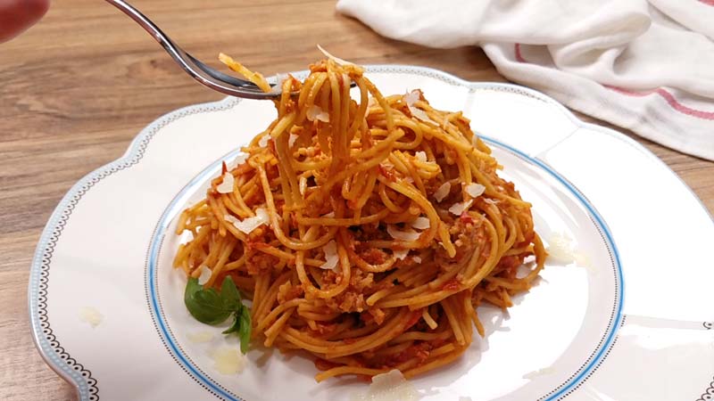 spaghetti on white plate, twirled around fork