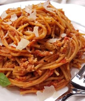 spaghetti with meat sauce on white plate with fork
