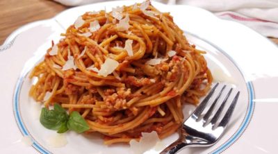 spaghetti with meat sauce on white plate with fork