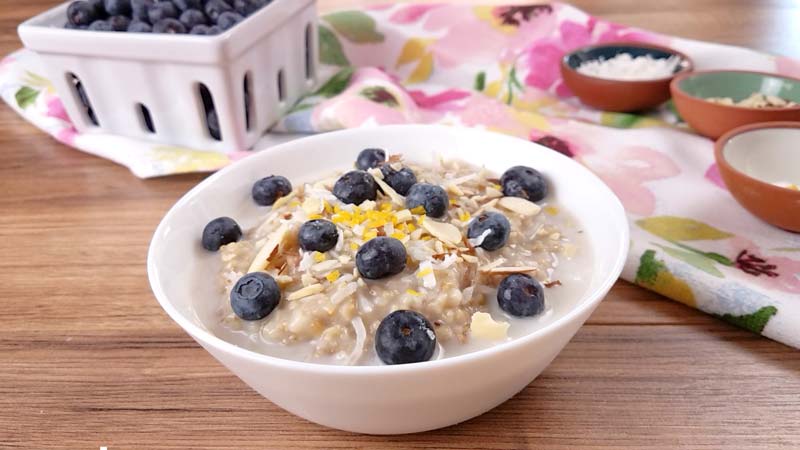steel cut oats with blueverry and lemon zest in white bowl
