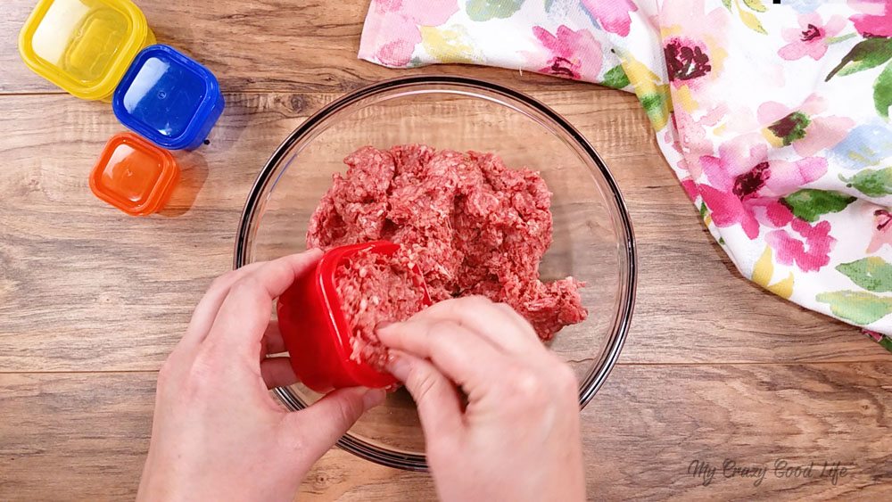 Add seasonings to ground beef and use red container to measure out meatball. 