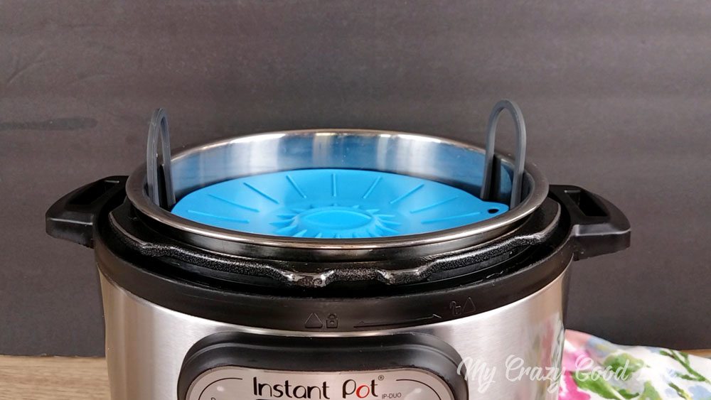 The inner pot covered by a silicone lid while making healthy spinach artichoke dip.