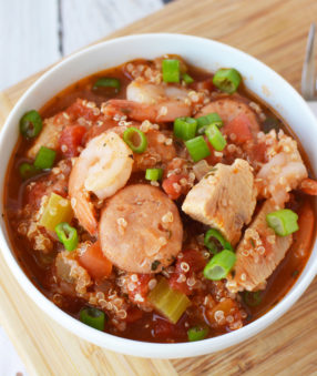 jambalaya in a white bowl on a wood table