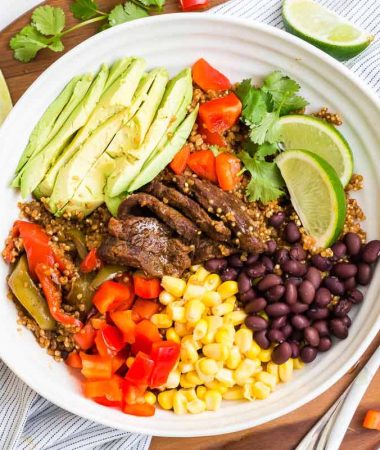 white bowl filled with steak fajitas and fresh toppings