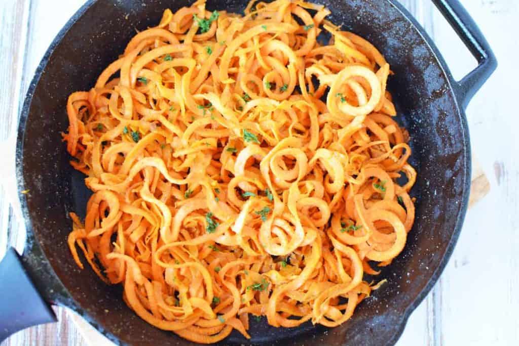 sweet potato pasta being cooked in a cast iron skillet