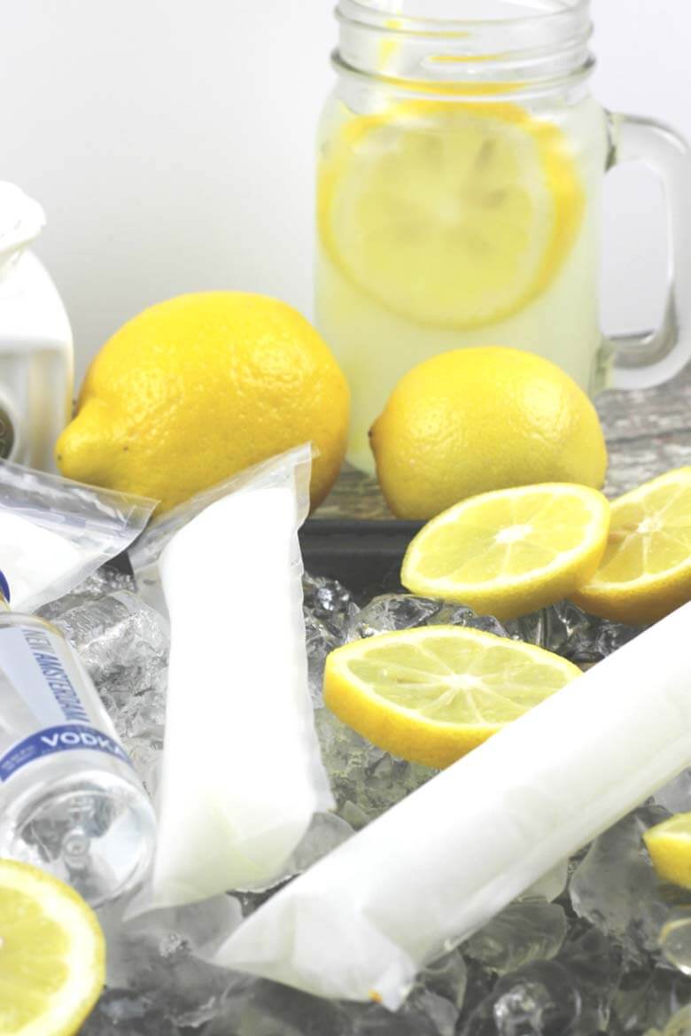 lemons, lemonade, and vodka popsicles on a dark countertop