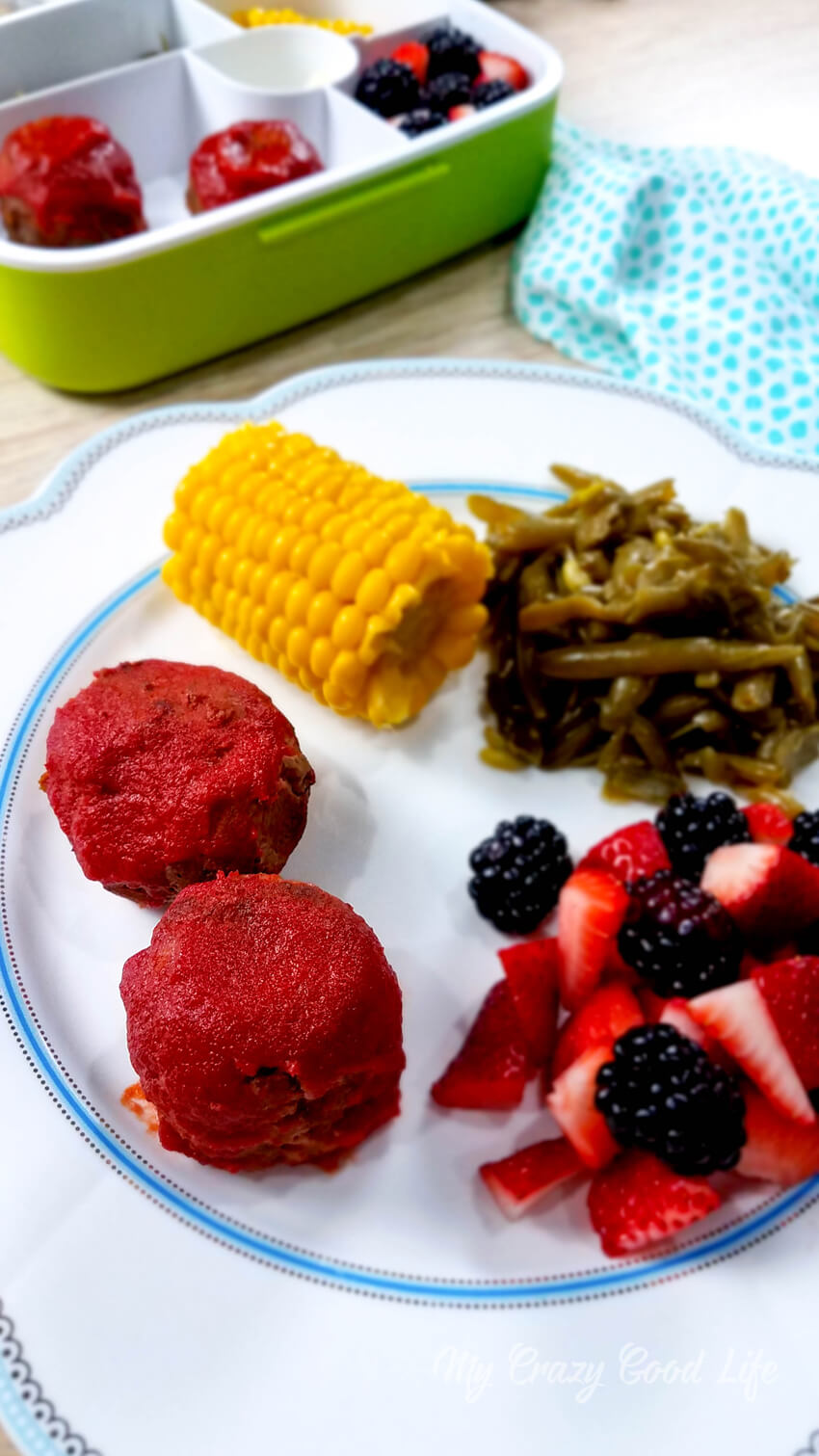 mini meatloaf on a white plate with corn and green beans