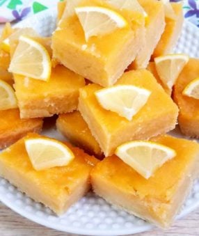 close up of cut lemon bars on a white plate
