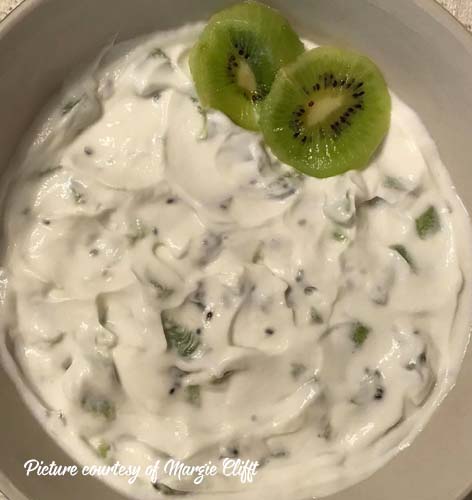 greek yogurt with chopped kiwi mixed in and two slices on top