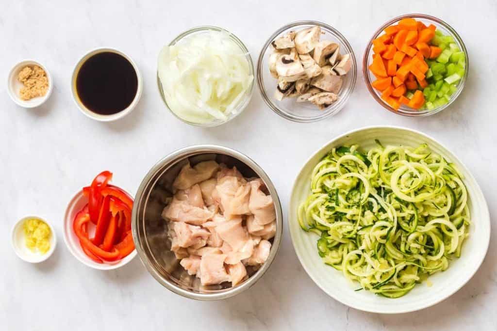 white counter with small bowls of ingredients for chicken lo mein