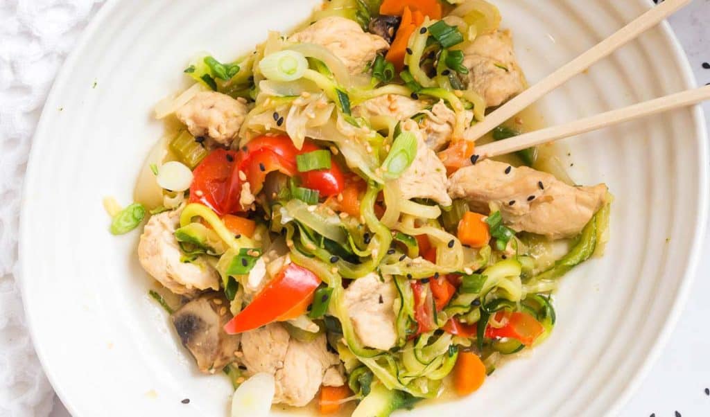 top down view of instant pot lo mein in a white bowl and chopsticks